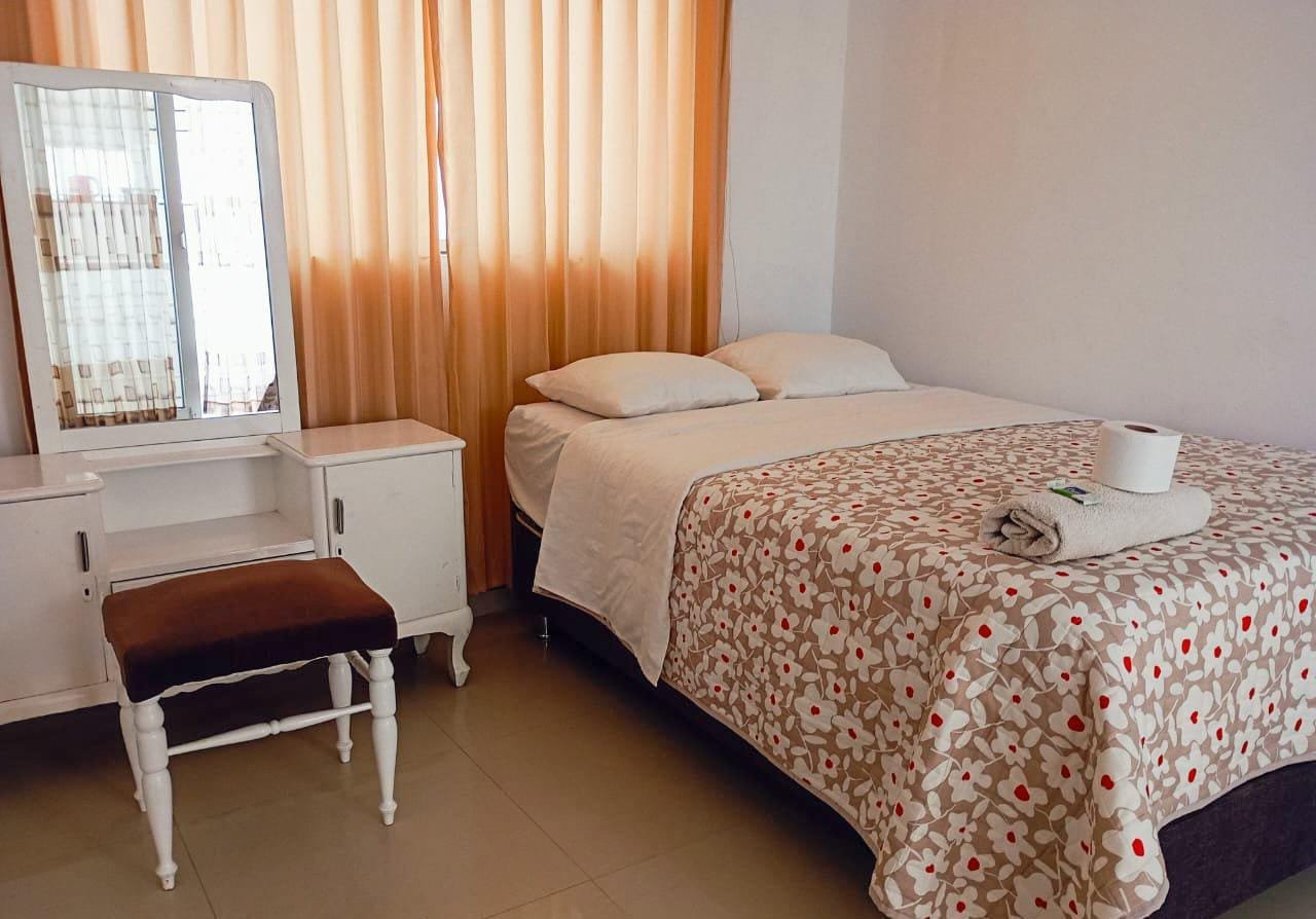 Habitación matrimonial con tocador de hospedaje en San Ramón, Chanchamayo. Cuenta con baño privado