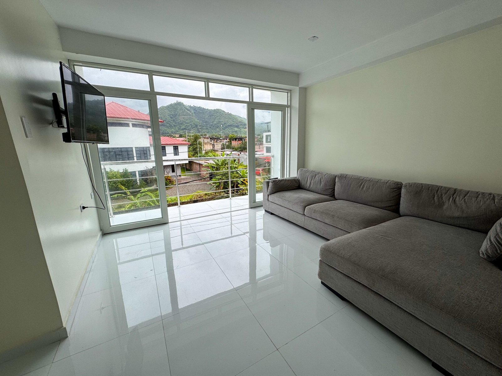 Sala acogedora y balcón en moderno departamento familiar de hospedaje en San Ramón, Chanchamayo. Cuenta con Wifi, Netflix y balcón con vista al bosque y capacidad para familiar o grupos grandes